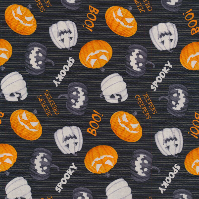 Tossed black, white, and orange jack-o-lanterns with spooky Halloween phrases on a black fabric background
