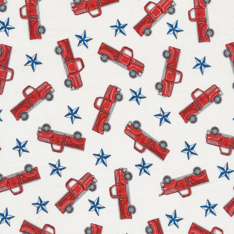 Patriotic fabric with tossed red vintage trucks and blue stars on a white background