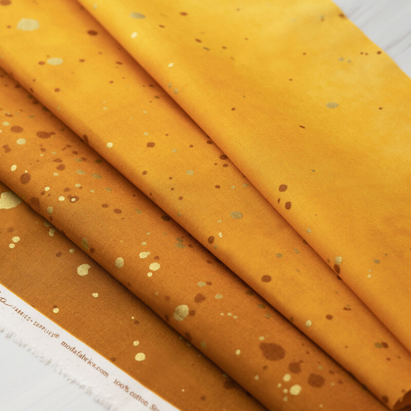 A mustard yellow ombre fabric with metallic accents.