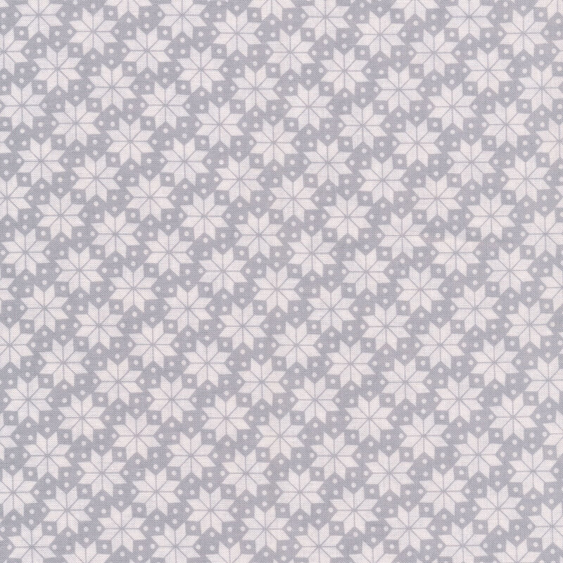 White geometric snowflakes and small polka dots fabric all over a gray background