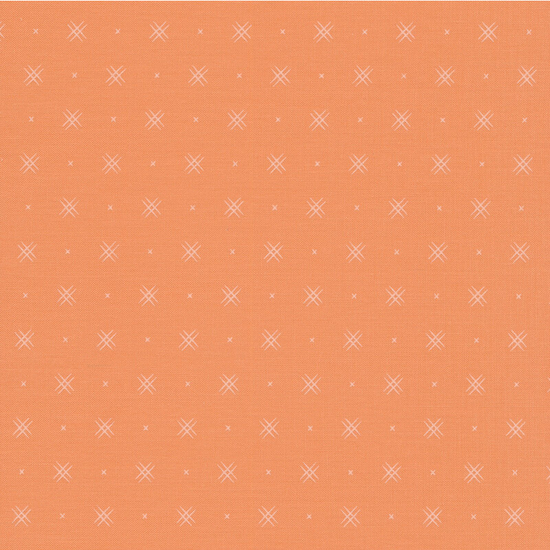 Coral colored fabric with rows of small white x's and double criss-cross patterns