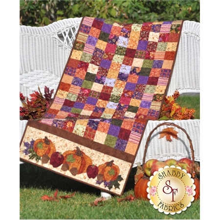 Table runner from purple, red, and orange patchwork squares with harvest pumpkin applique on ends.