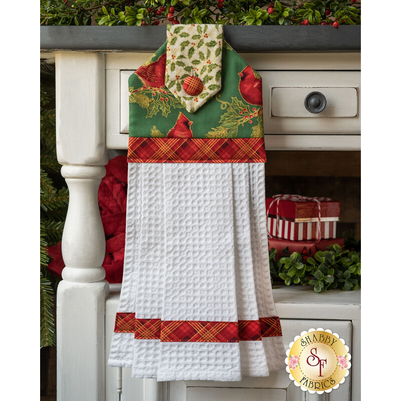Green hanging towel featuring metallic holly and cardinal print with red gingham and cream accents.