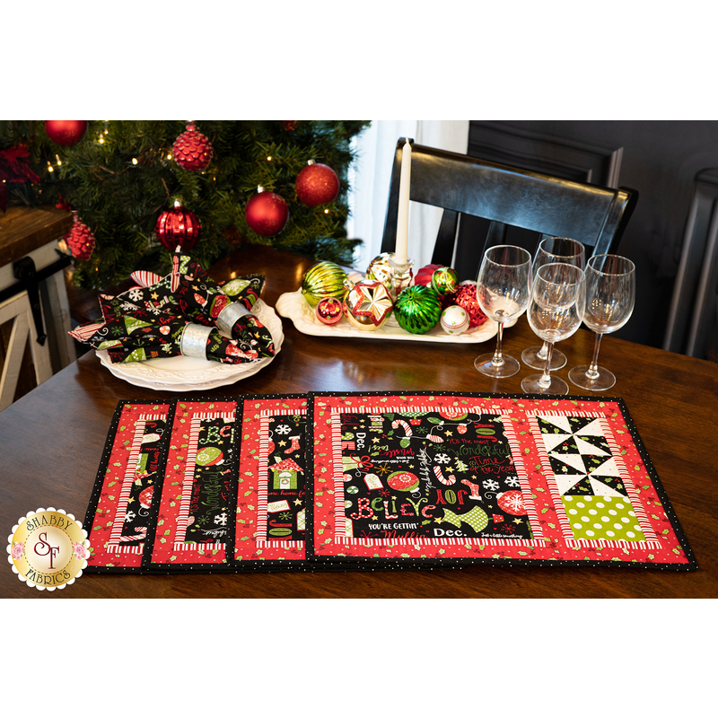 A set of 4 Christmas placemats on a wood table