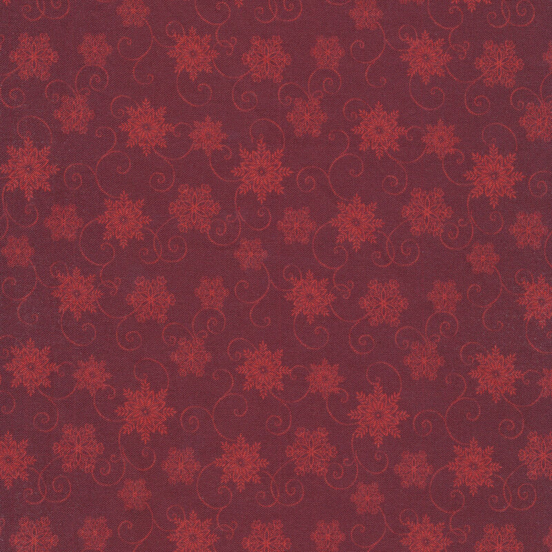 Tonal red fabric with light red snowflakes and scrolls on a dark red background
