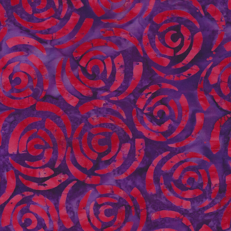 Abstract red roses on a purple Batik fabric background.