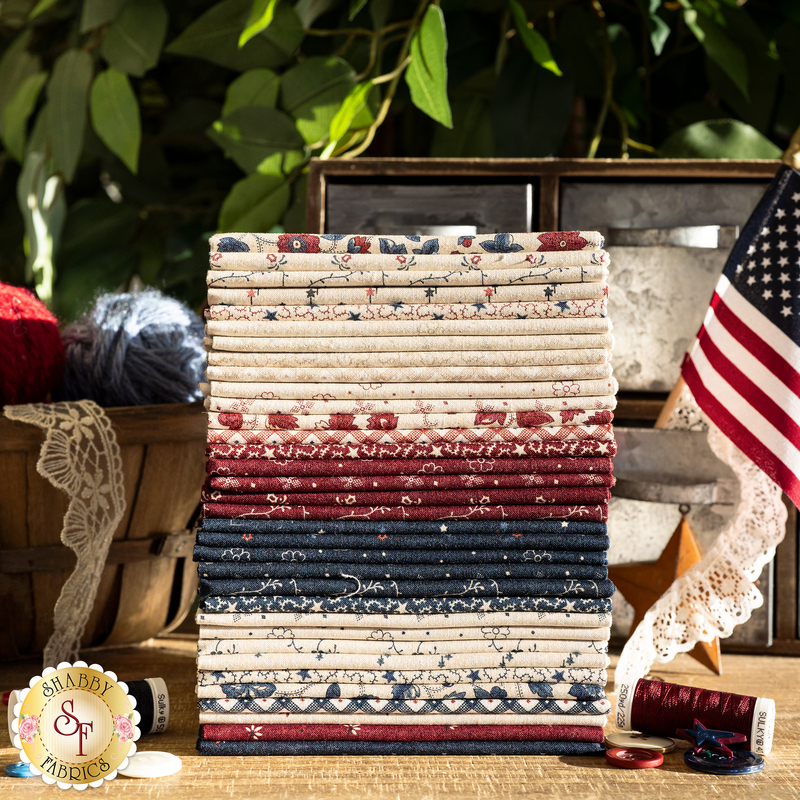 A stack of patriotic colored fabrics consisting of flowers, gingham, stars, and leaves and vines.