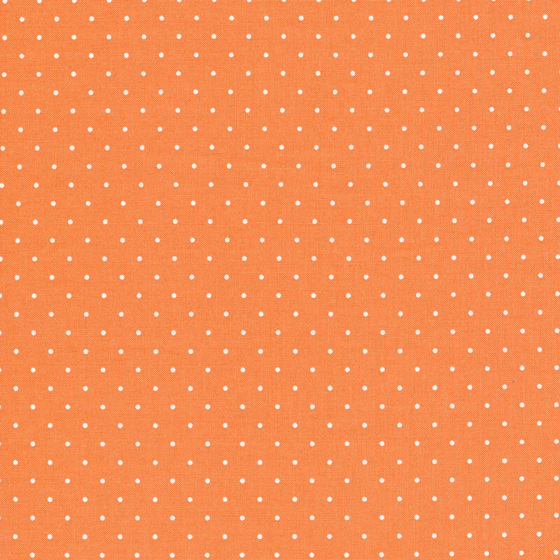 Peach colored fabric with small white polka dots all over