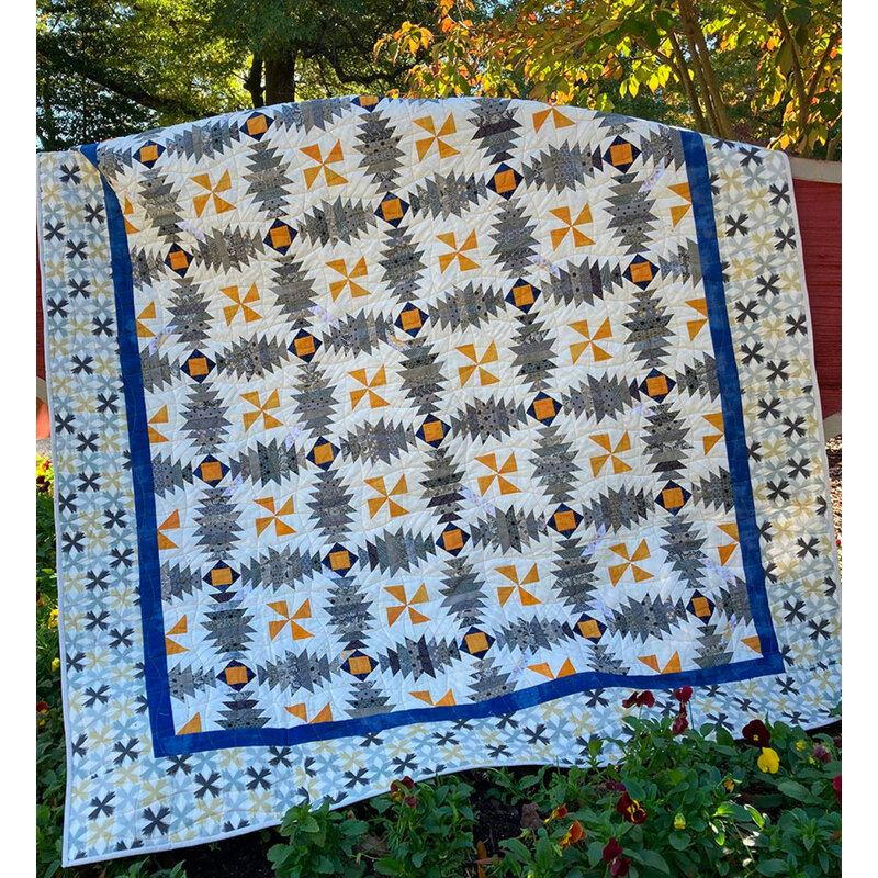 The beautiful Pineapple Pinwheels quilt displayed outdoors