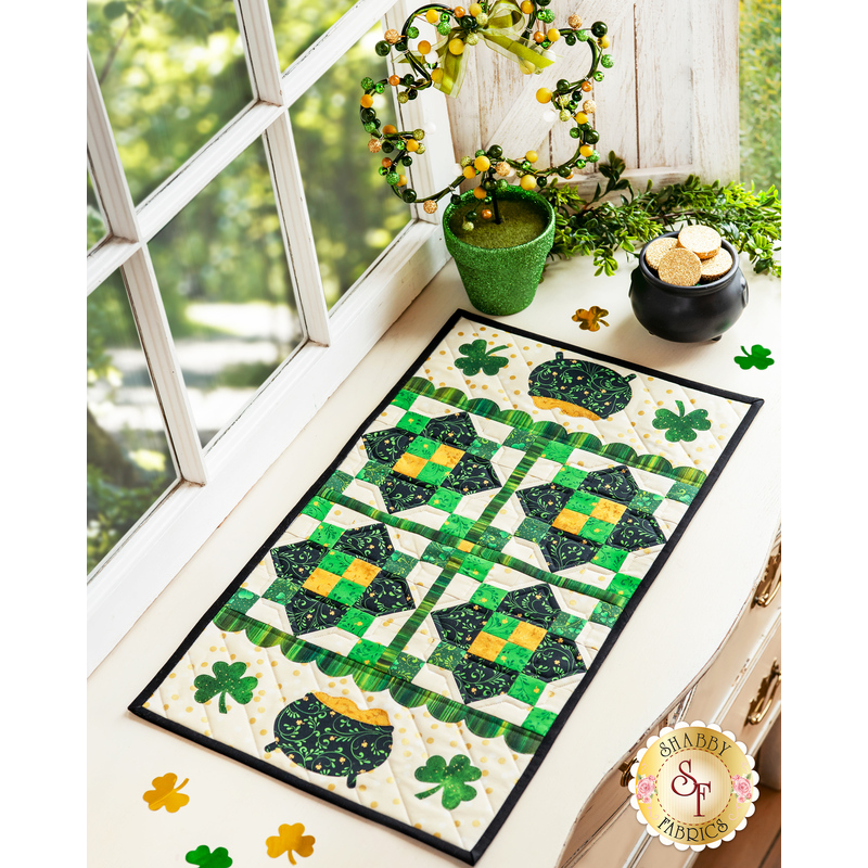 Cream table runner featuring green clovers, pots of gold, and geometric designs.