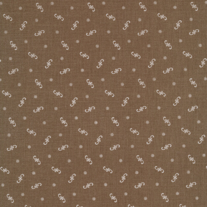 Ditsy fabric with white floral flourishes and dots on a brown background
