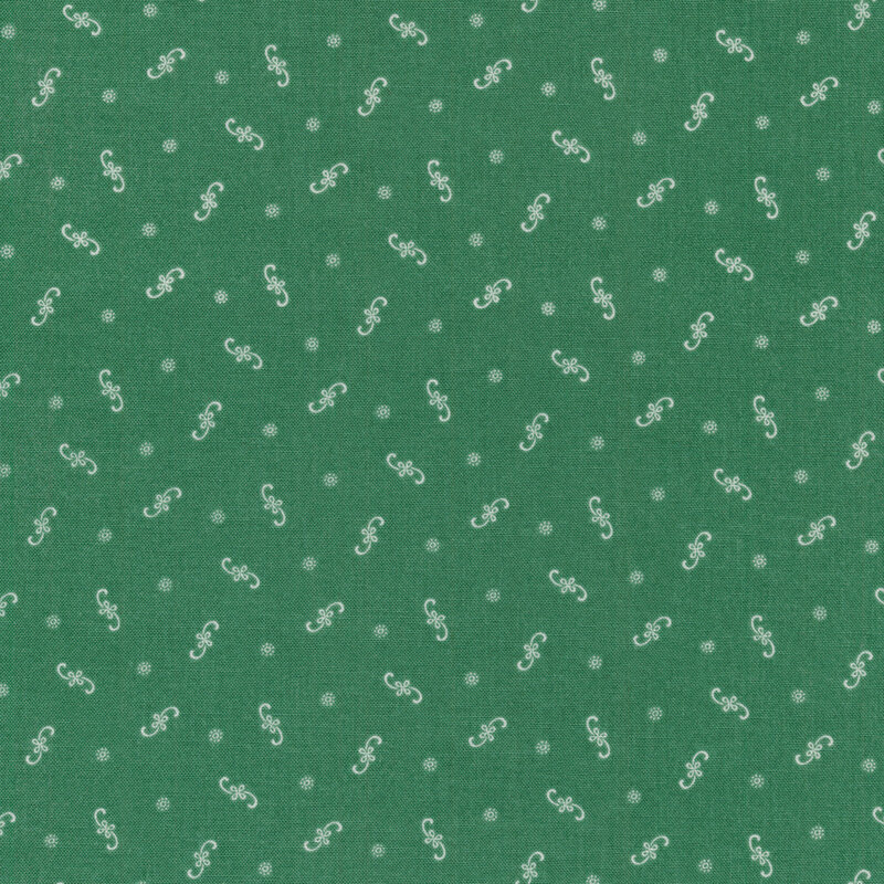 Ditsy fabric with white floral flourishes and dots on a green background
