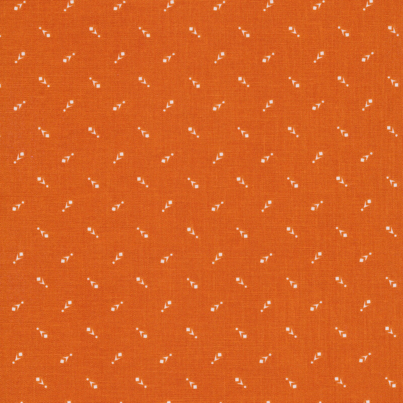 Fabric of a geometric print with small chevrons, dots, and squares on an orange background