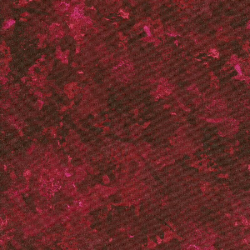 A fabric with a mottled watercolor texture in a dark berry color