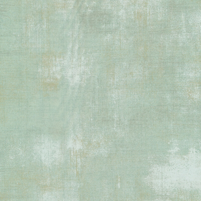 Close up image of Grunge Basics Mint fabric. Pale green with intentional, discolored imperfections
