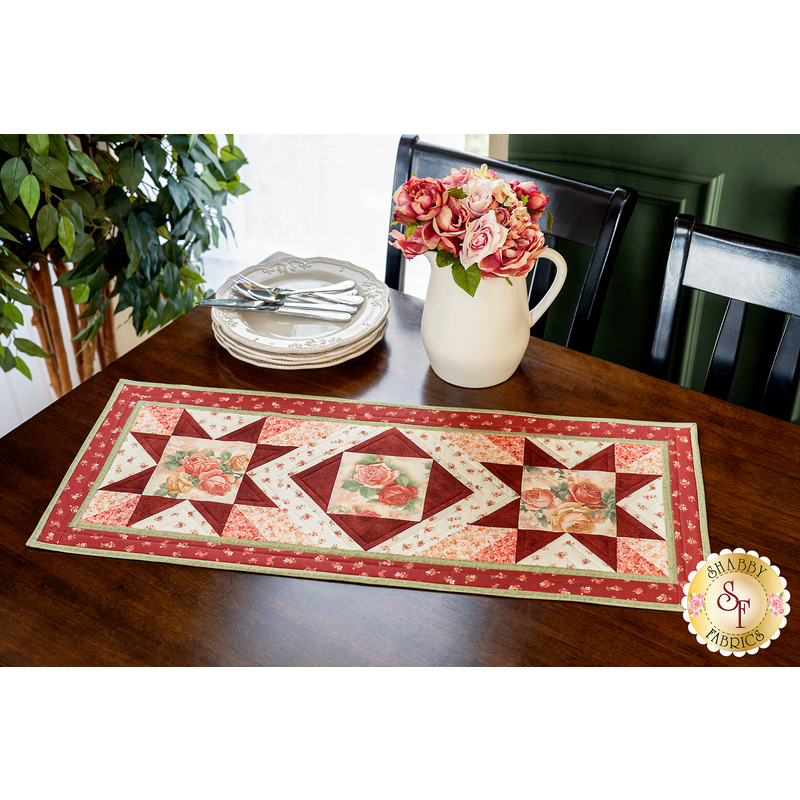 Red, pink, and cream table runner with geometric designs and floral prints.