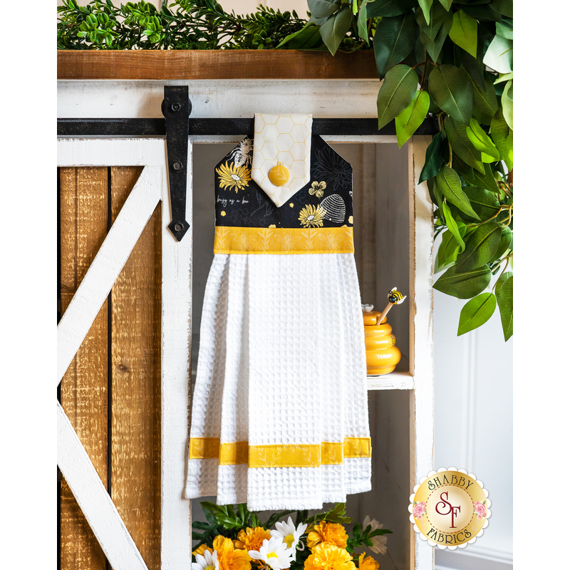 Hanging towel made of black bee themed fabrics with white and yellow accents.