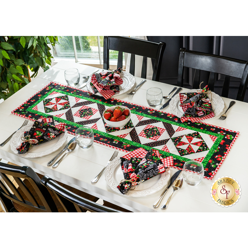 Image of table set for four with napkins and table runner featuring fabrics from the Strawberry Fields collection