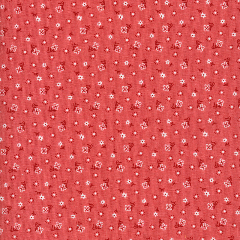 white flowers with dark red stems and polka dots scattered all over a pink fabric background