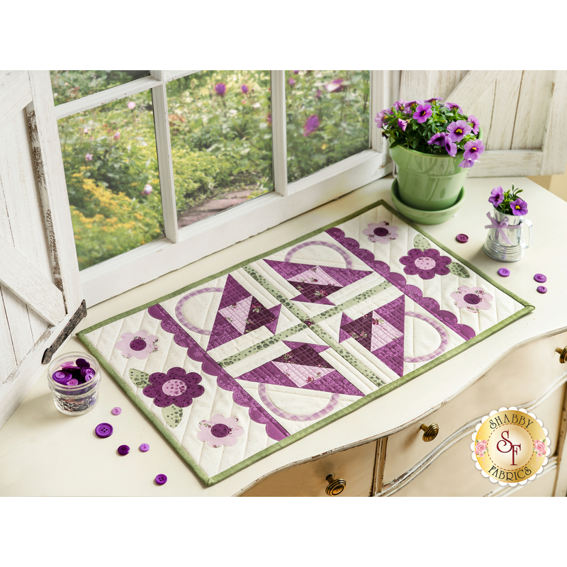 Table runner with geometric triangle and scallop design with appliqué flowers on the ends.