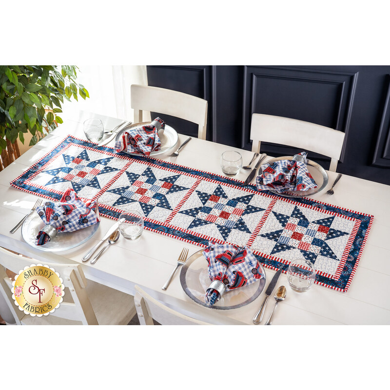 Table runner with four blocks of geometric designs featuring patriotic red, white, and blue fabrics.