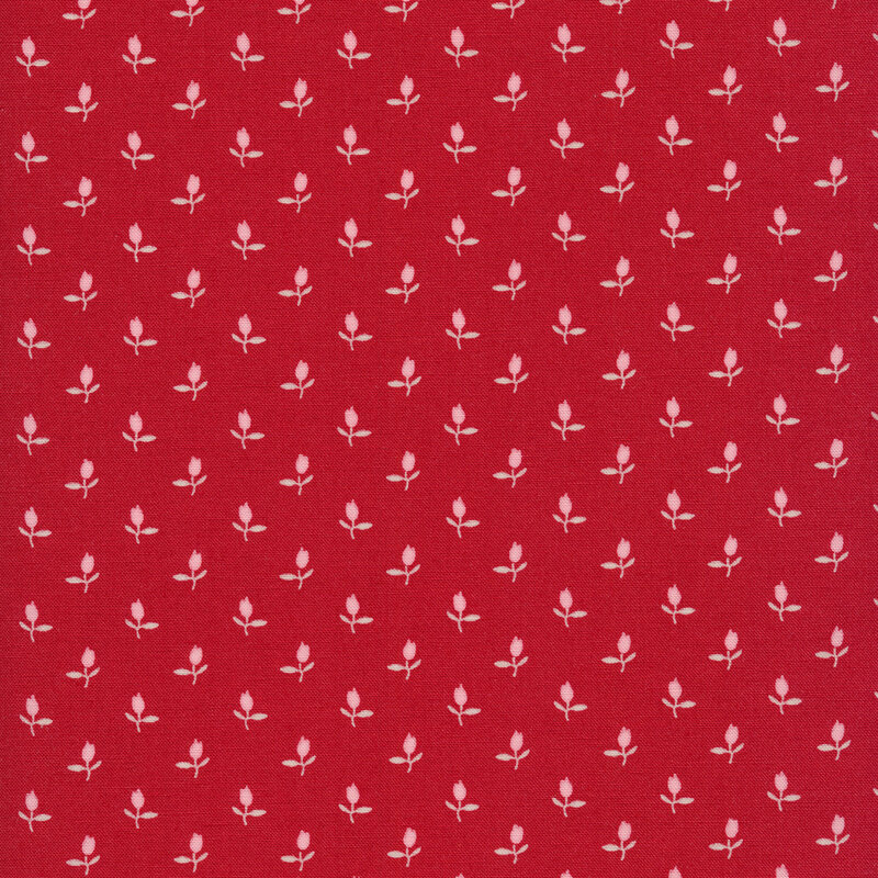 Fabric of a ditsy pink rosebud flower print on a red background.