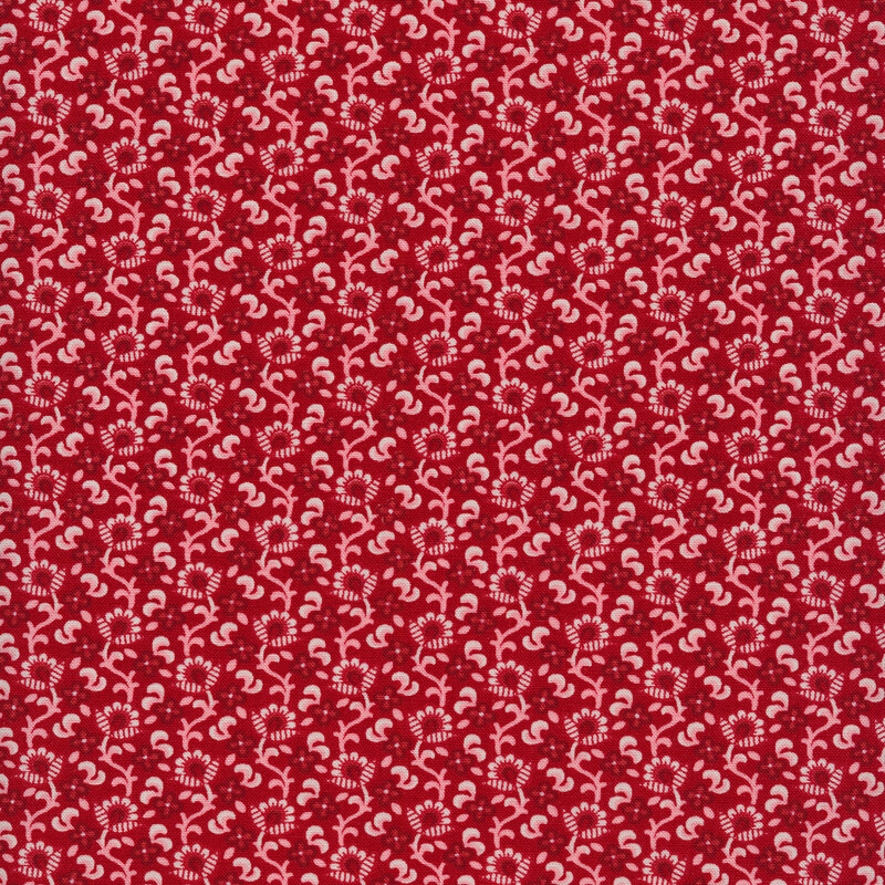Fabric of a white and red floral and vine print on a red background.
