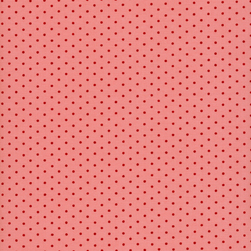 Fabric of red polka dots on a pink background.