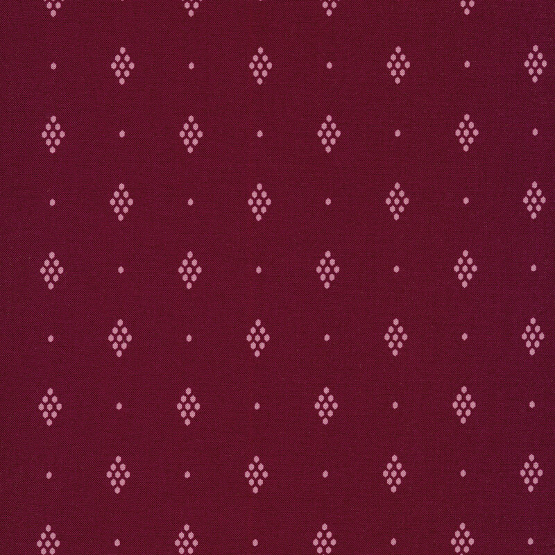 Fabric of pink diamonds made out of honeycomb shaped dots on a berry colored background