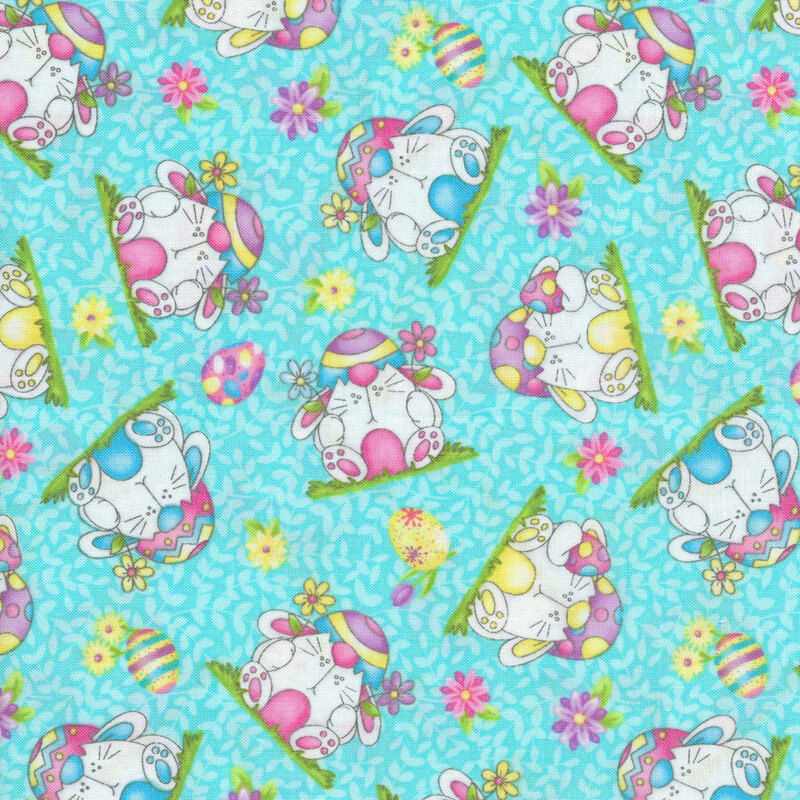 Fabric of scattered round bunnies wearing Easter eggs, surrounded by more Easter eggs and flowers on a blue background