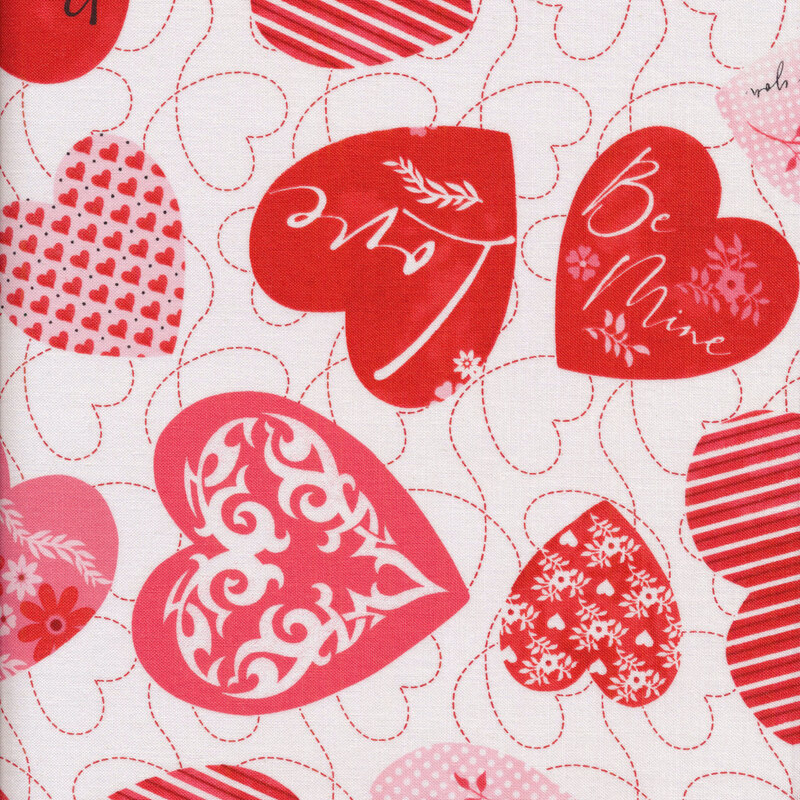 Fabric with multiple hearts in different shapes and sizes in classic red, pink, and white, with designs of florals, words, stripes, and swirls on a white background