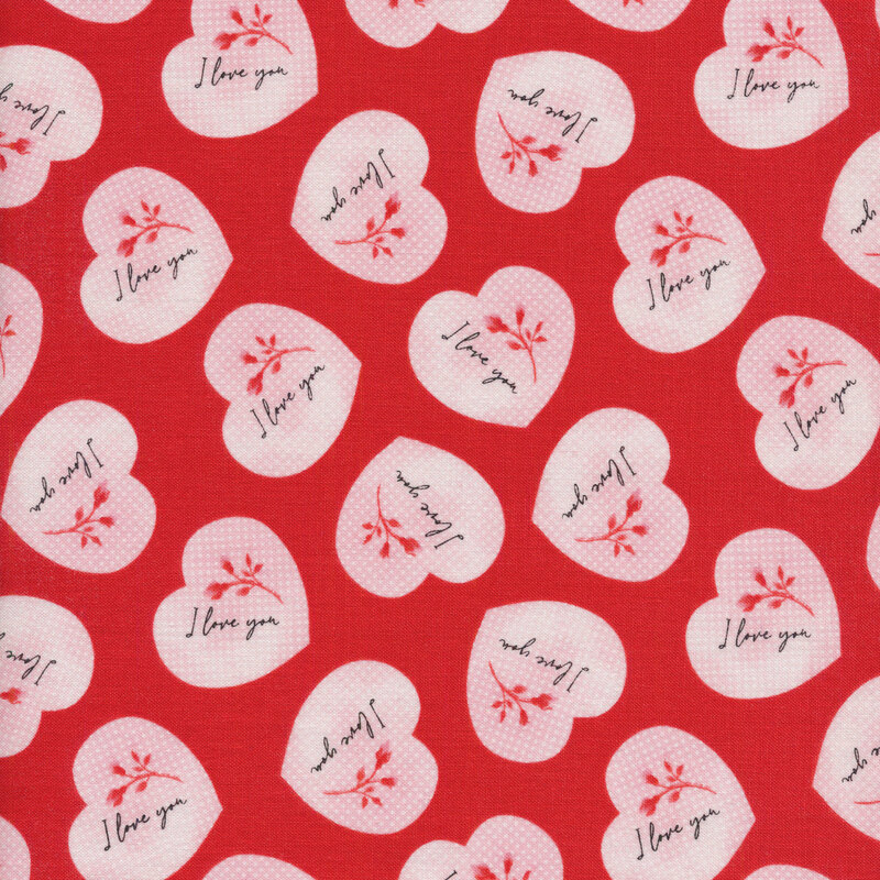 Fabric with pink hearts that say I Love You on a red background