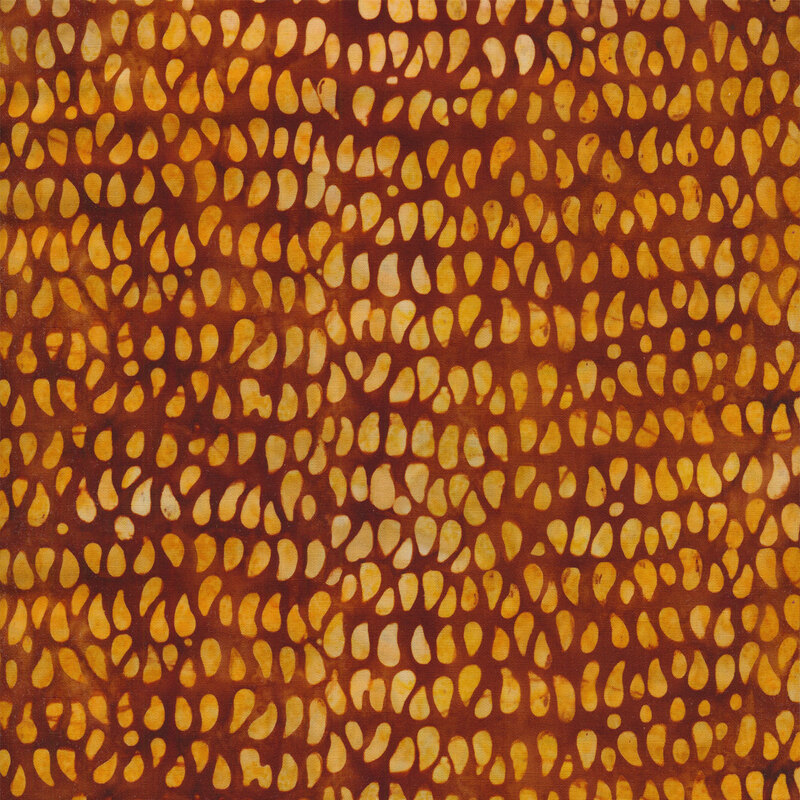 Mottled fabric of yellow teardrop dots on a brown background.