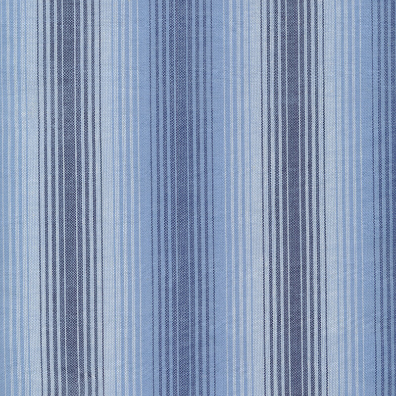 Woven fabric with stripes in varying sizes in light blue, cream, and navy.
