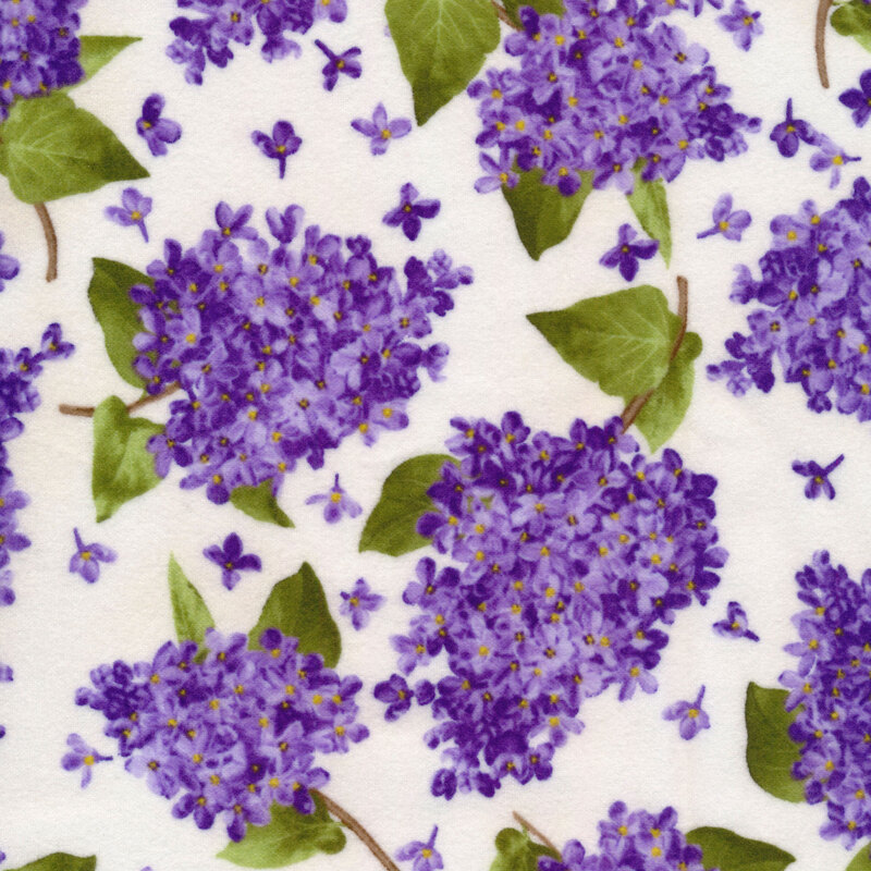 Fabric featuring clusters of lilacs on a white background