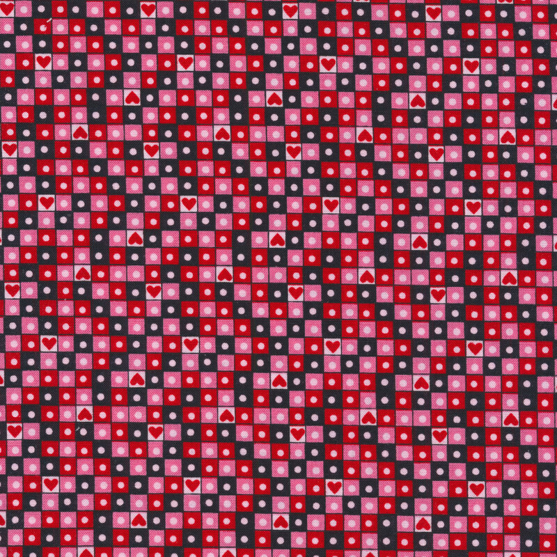 A pink Valentine's day fabric with red, pink, and light pink squares in a grid pattern with circles and hearts