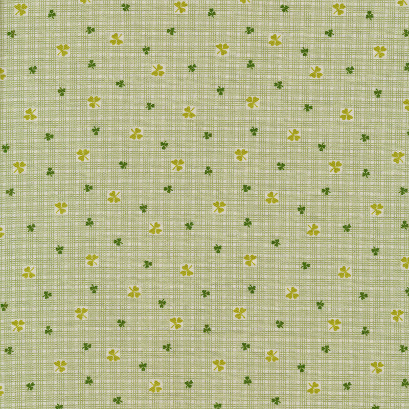 Light green fabric with a light grid background and tossed clovers and shamrocks all over