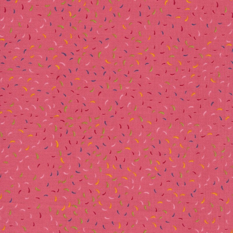 Pink fabric with tossed colorful confetti all over