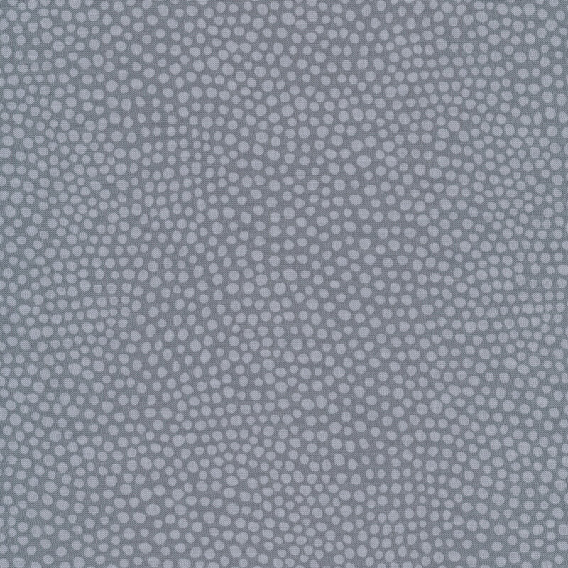 Tonal grey fabric with light grey polka dots all over a dark grey background