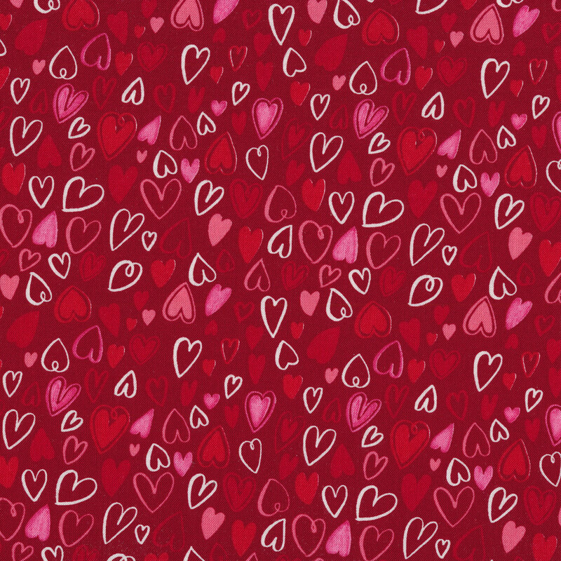 Fabric with red, white, and pink hearts all over a red background