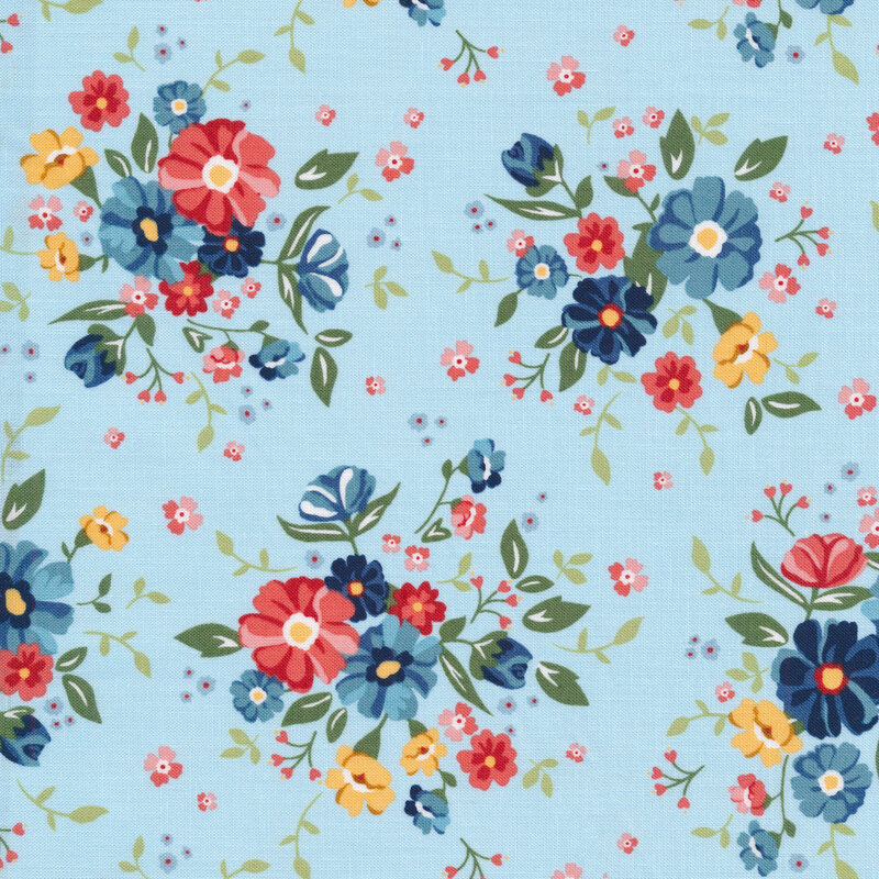 pale blue fabric with clusters of flowers in varying shades of red, blue and yellow with small green leaves
