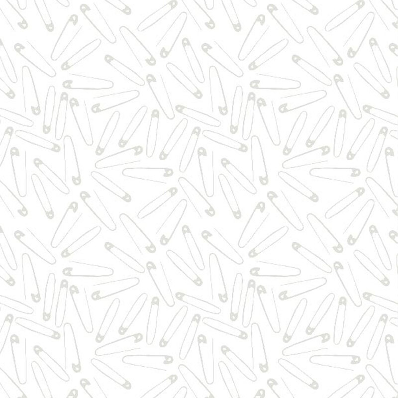light grey safety pins scattered all over a white fabric background