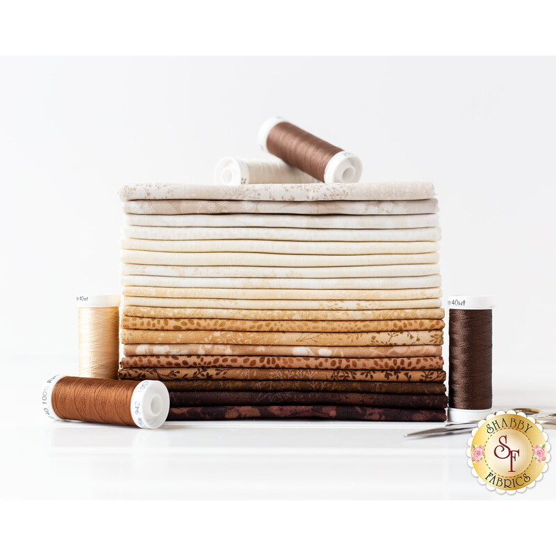 photo of a brown and cream colored fabric fat quarter set stacked neatly with spools of thread around it