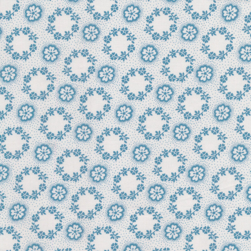 Cream fabric evenly covered in tiny flower wreaths and flowers