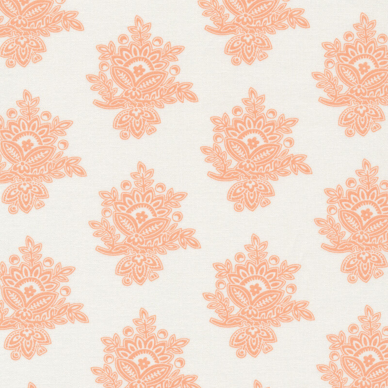 cream colored fabric with large, peach colored, intricate embellishments