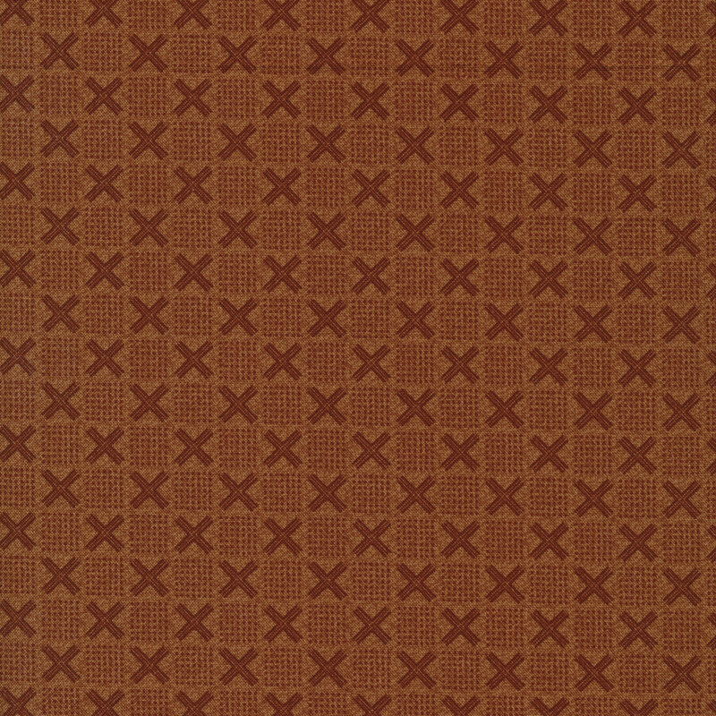 Dusty orange fabric with x's and squares made of dots in a checker pattern