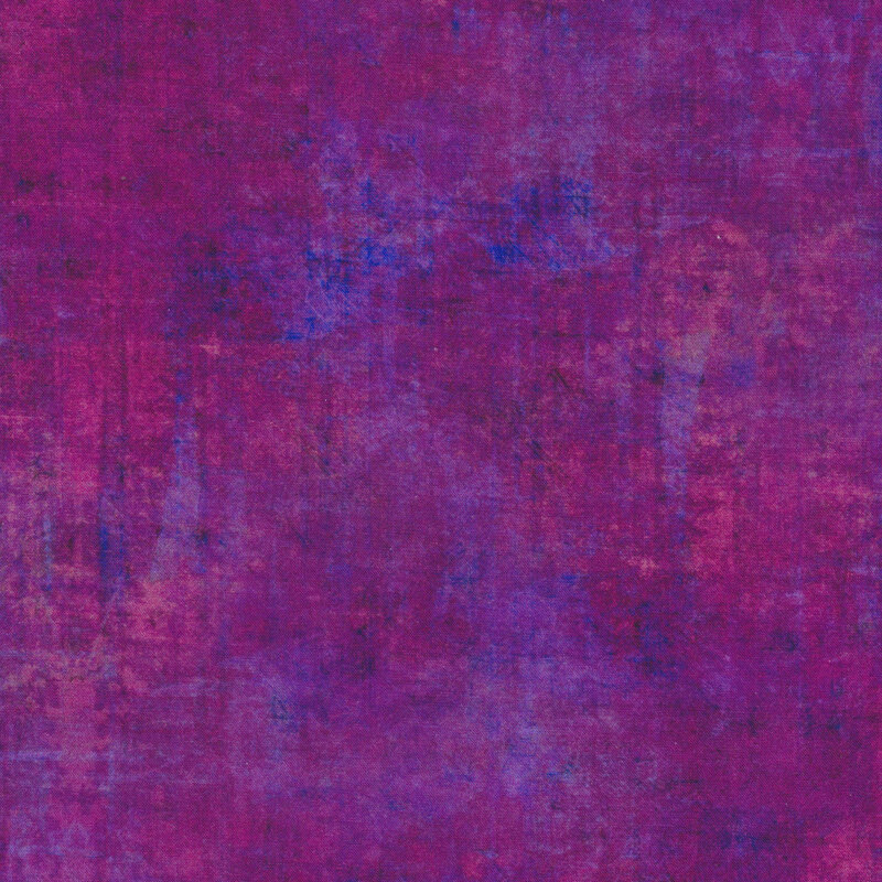 A mottled magenta fabric with a grunge texture look with bits of blue and bright pinks peeking through