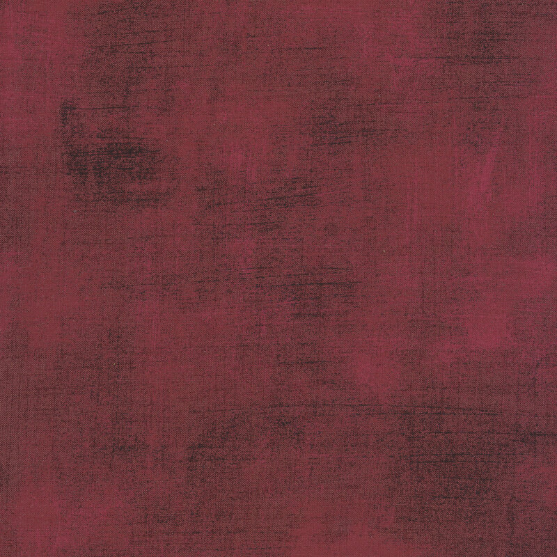 Reddish pink fabric with bits of black grunge texturing