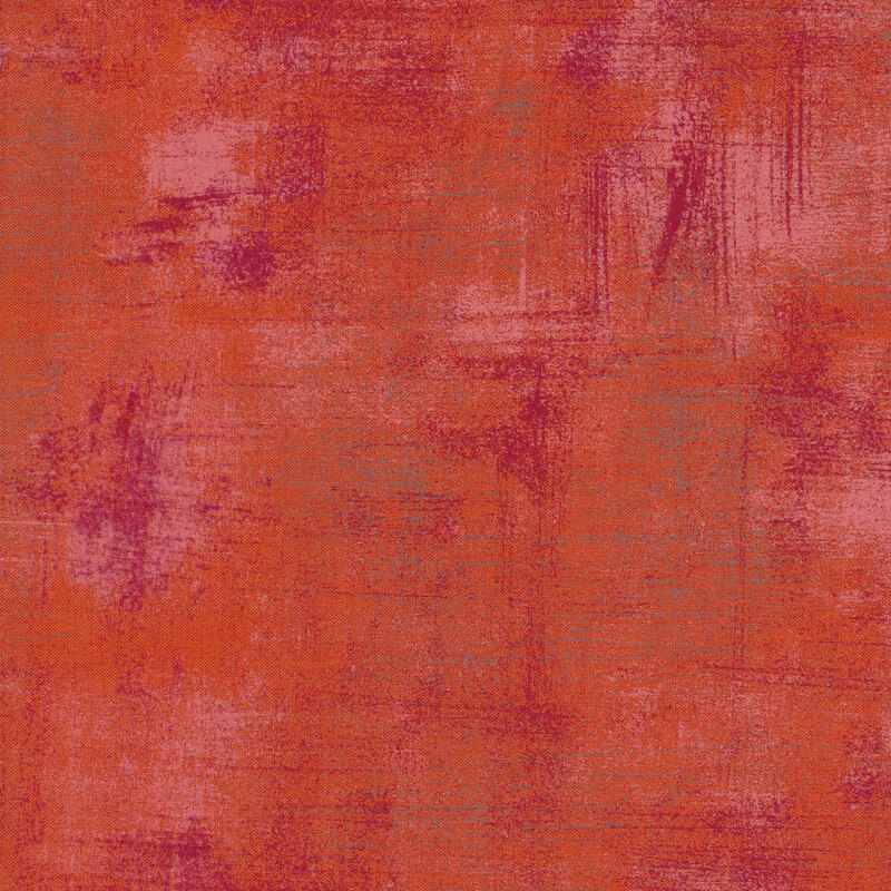 Bright reddish orange fabric with bits of dark purple grunge texturing