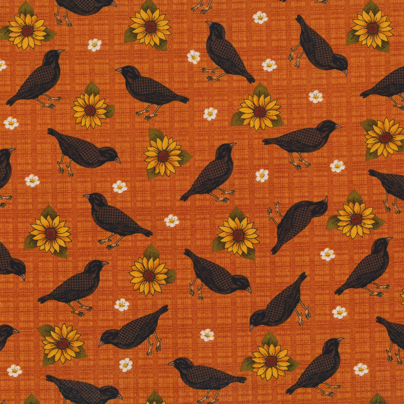 Sewing fabric with small flowers, black birds, and sunflowers all over an orange background